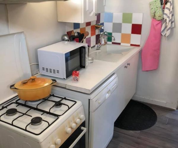 Ancien coin cuisson avec cuisinière et crédence colorée avant rénovation