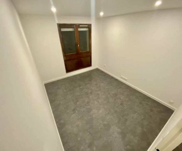 Chambre rénovée avec dalles PVC effet béton au sol