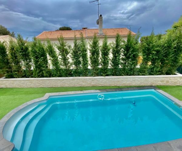 Jardinière en parement Orsol Grand Canyon et margelles travertin autour d’une piscine à Carry-le-Rouet