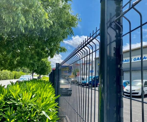Clôture rigide installée en remplacement d’un grillage souple sur un site commercial