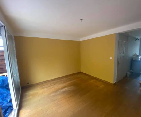 Séjour rénové à Martigues avec mur jaune et parquet clair