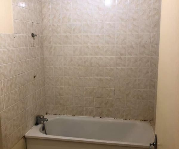 Ancien carrelage beige usé dans une salle de bain avant rénovation à Aix-les-Milles